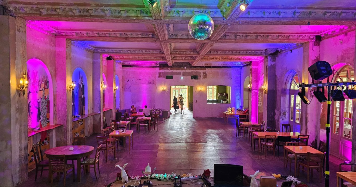 Villa Hasenholz Festsaal mit Ambientebeleuchtung und Tischanordnung für eine Veranstaltung.